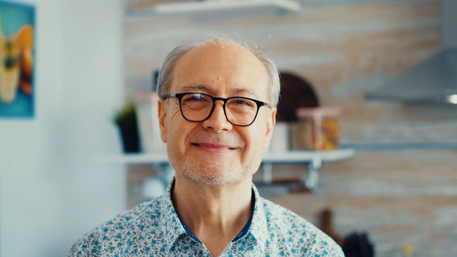 A resident in glasses smiling warmly