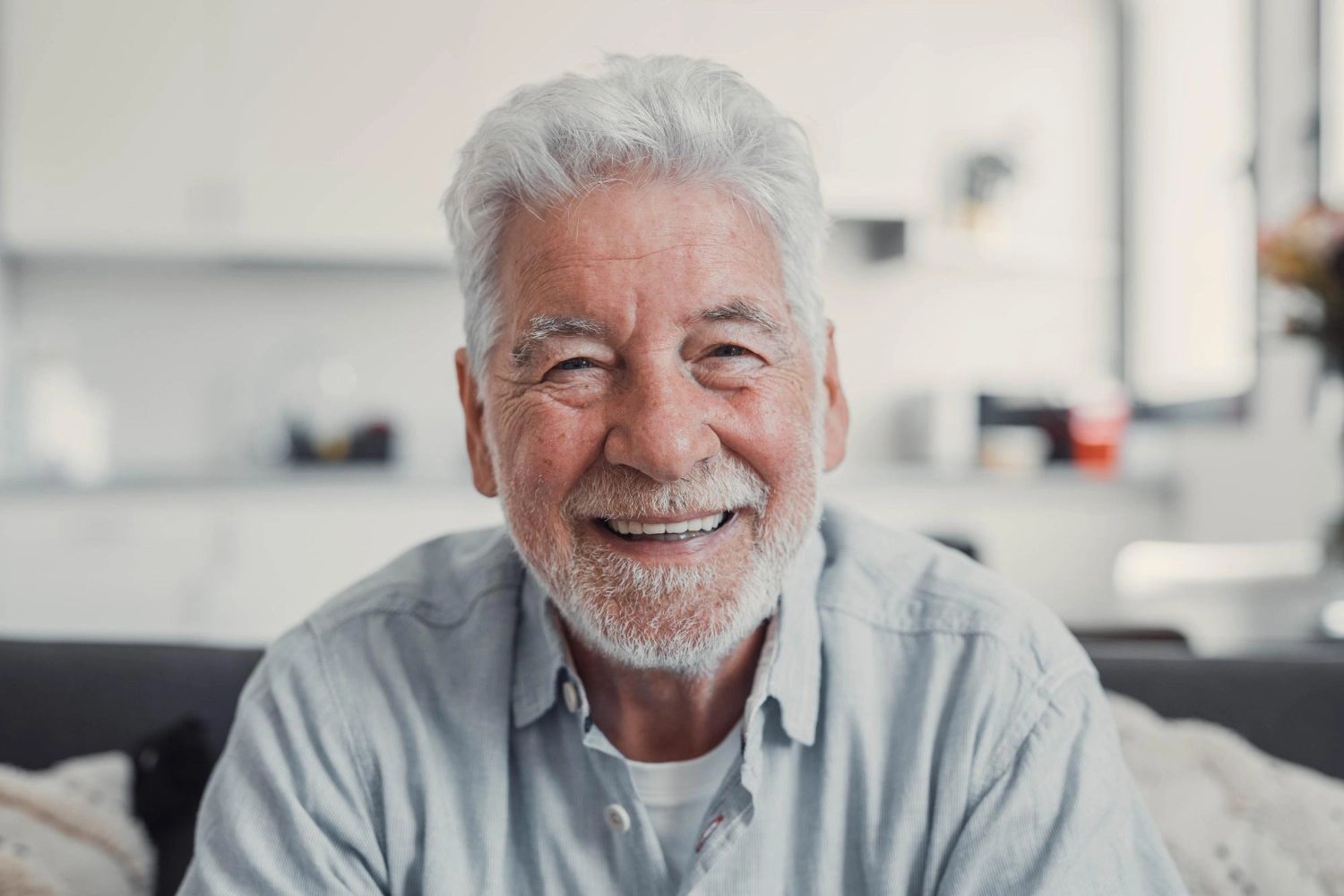 A resident with a white beard smiling