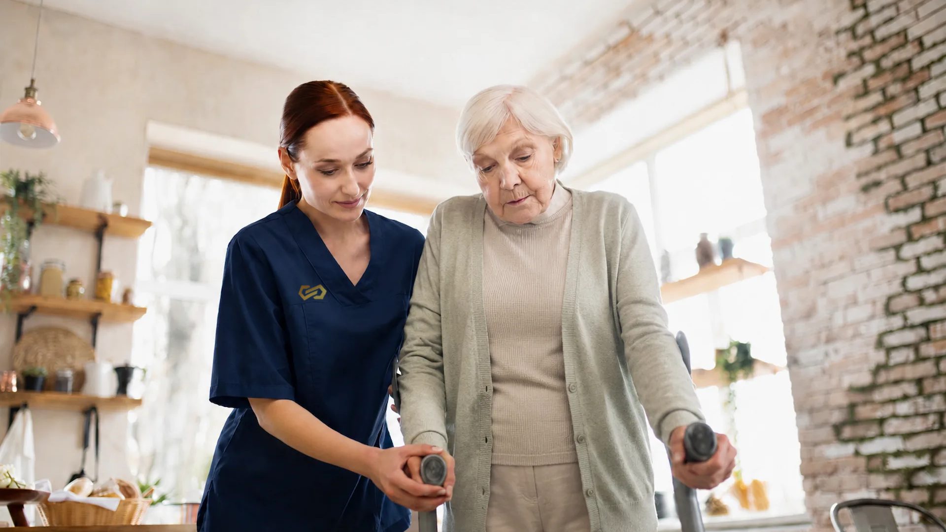 A nurse walks alongside an older woman who is using forearm crutches