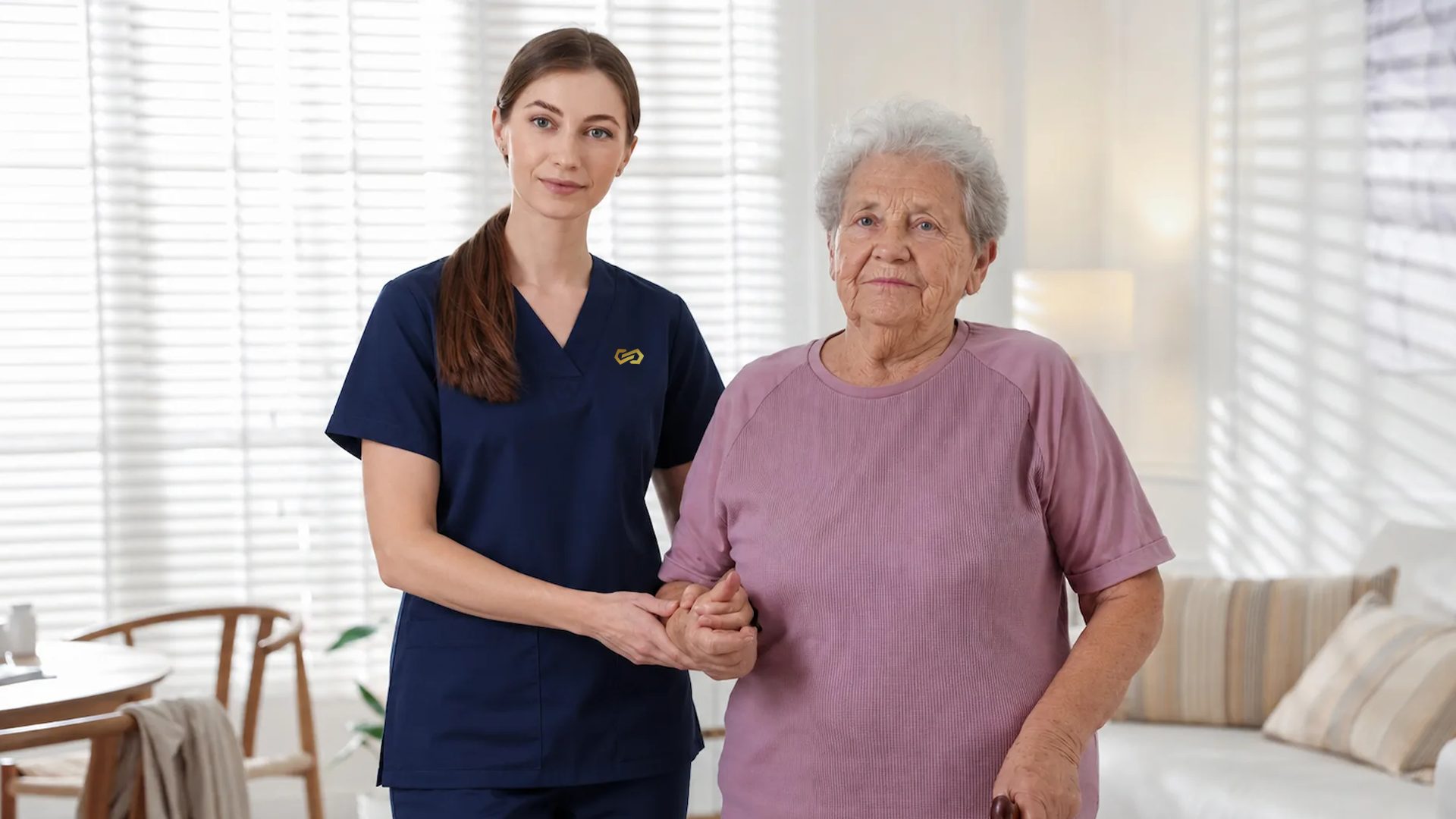 A nurse stands hand in hand with an older woman who uses a walking cane