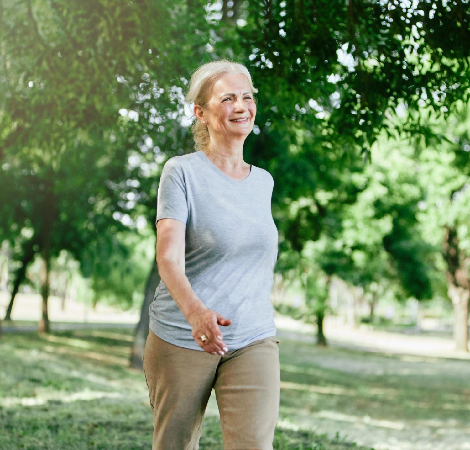 A resident walking under the trees on the grounds